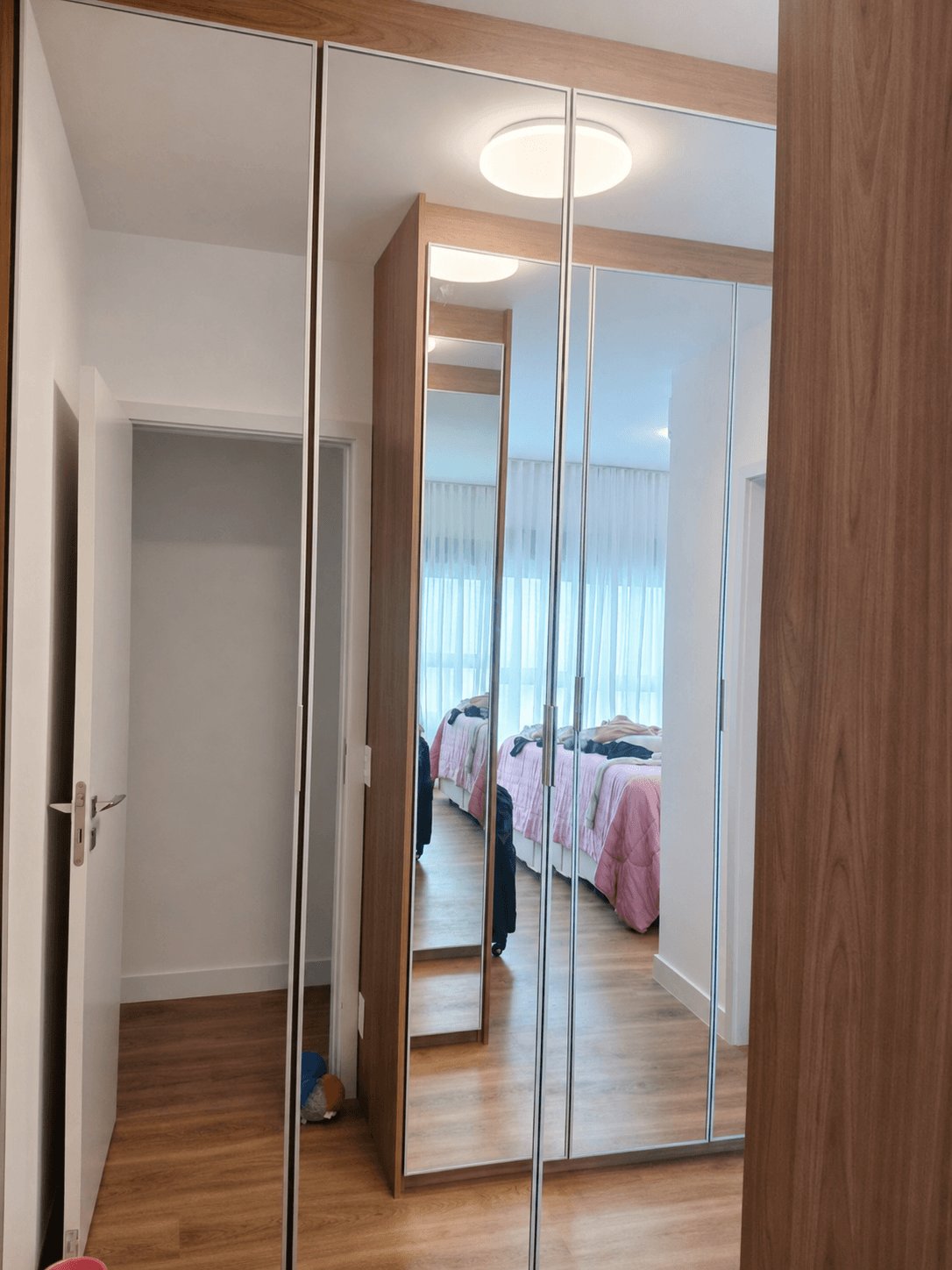 Guarda-roupa planejado com portas espelhadas e acabamento amadeirado